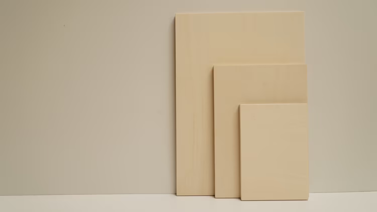 Three clean Sustainable Ply art boards in three sizes leaning against a soft-lit studio wall