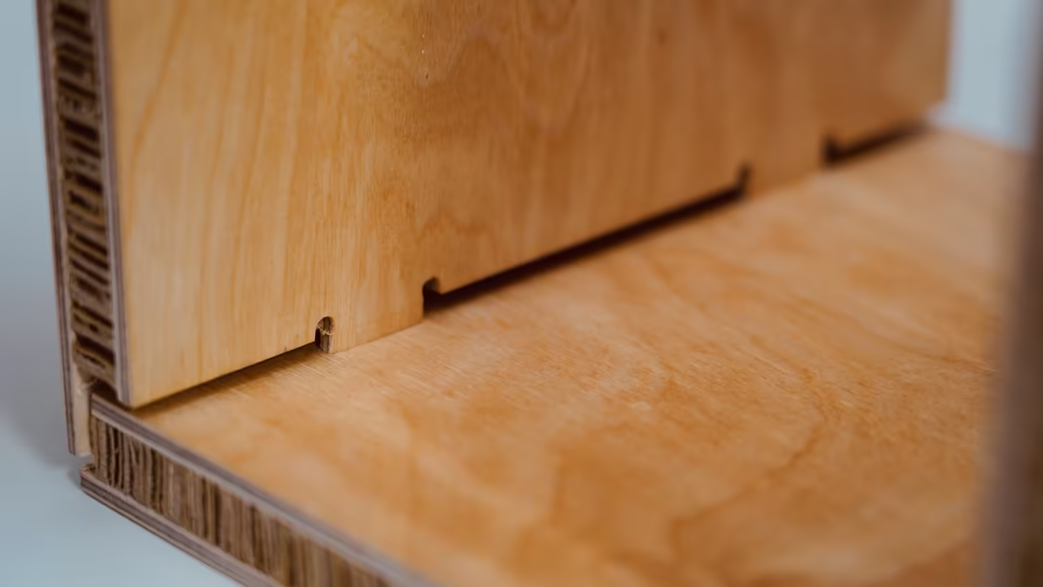Close-up of CNC-cut Sustainable Ply joinery showing the cardboard honeycomb edge